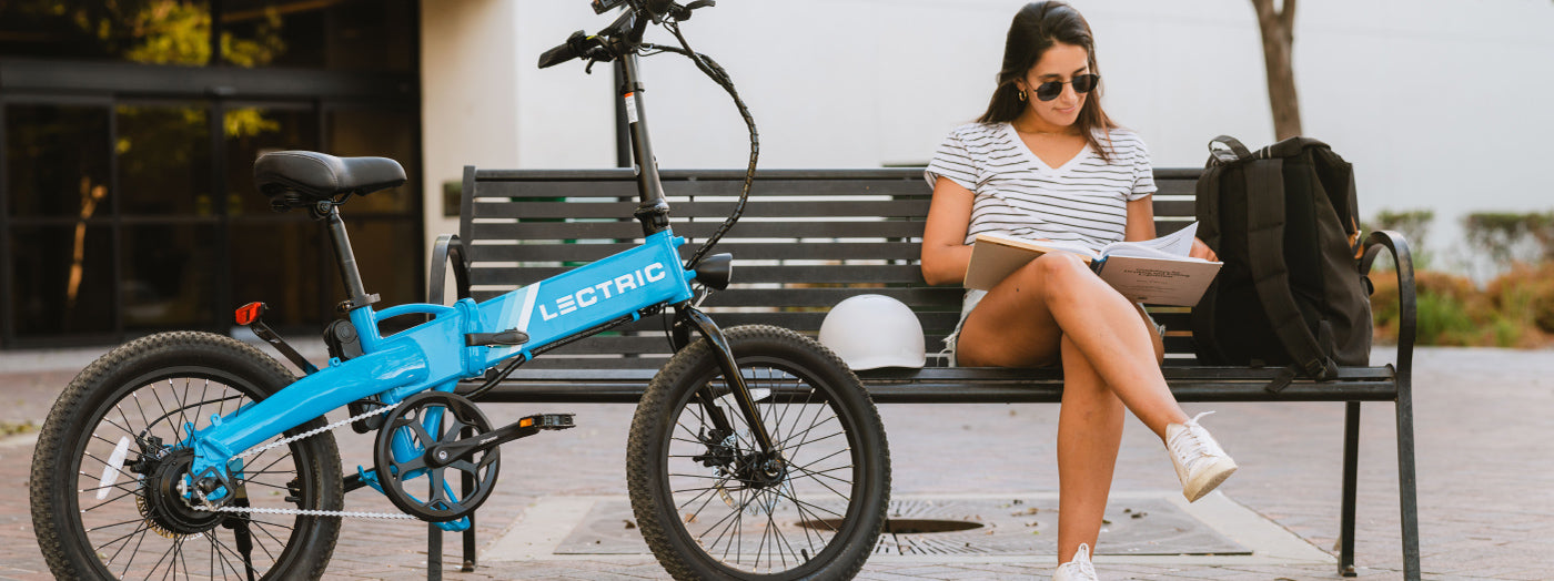 Étudiant universitaire qui lit un manuel expliquant le trajet quotidien avec Lectric eBikes XP Lite 