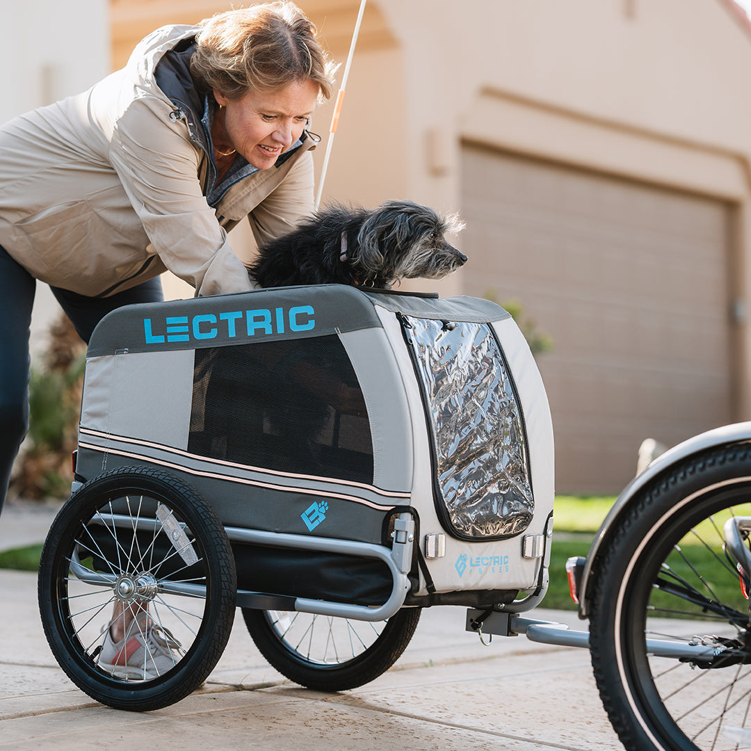femme qui place le chiot dans la cage de transport Wag-Along à l’arrière de son trike XP