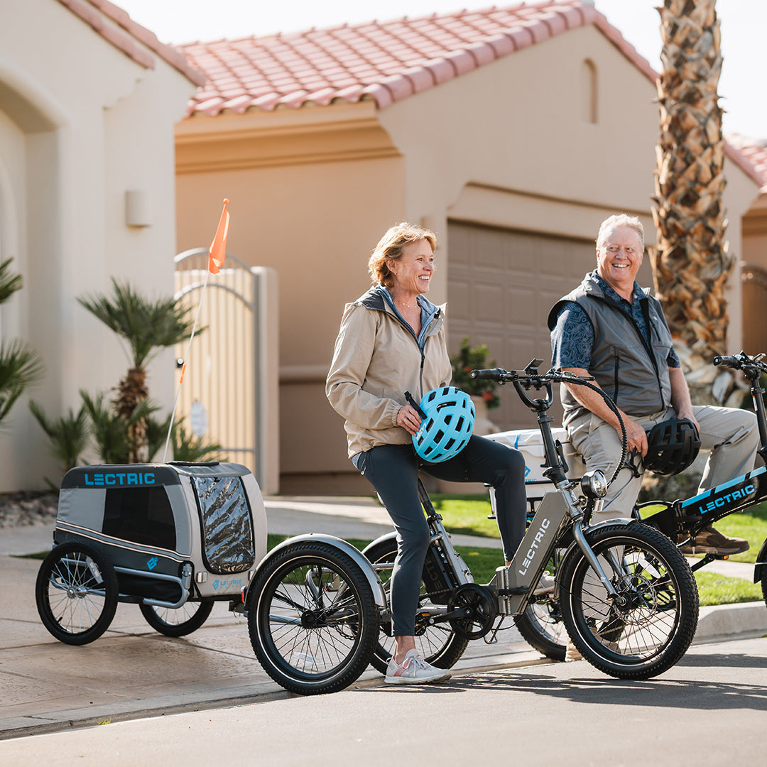 un homme et une femme à bord d’un XP Trike et d’un XP 3.0 dans le quartier de la cage de transport Wag Along